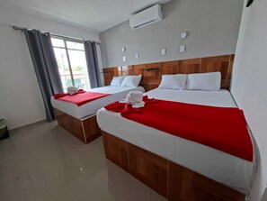A hotel room with two beds, a window with curtains, an air conditioning unit, and a tiled floor.