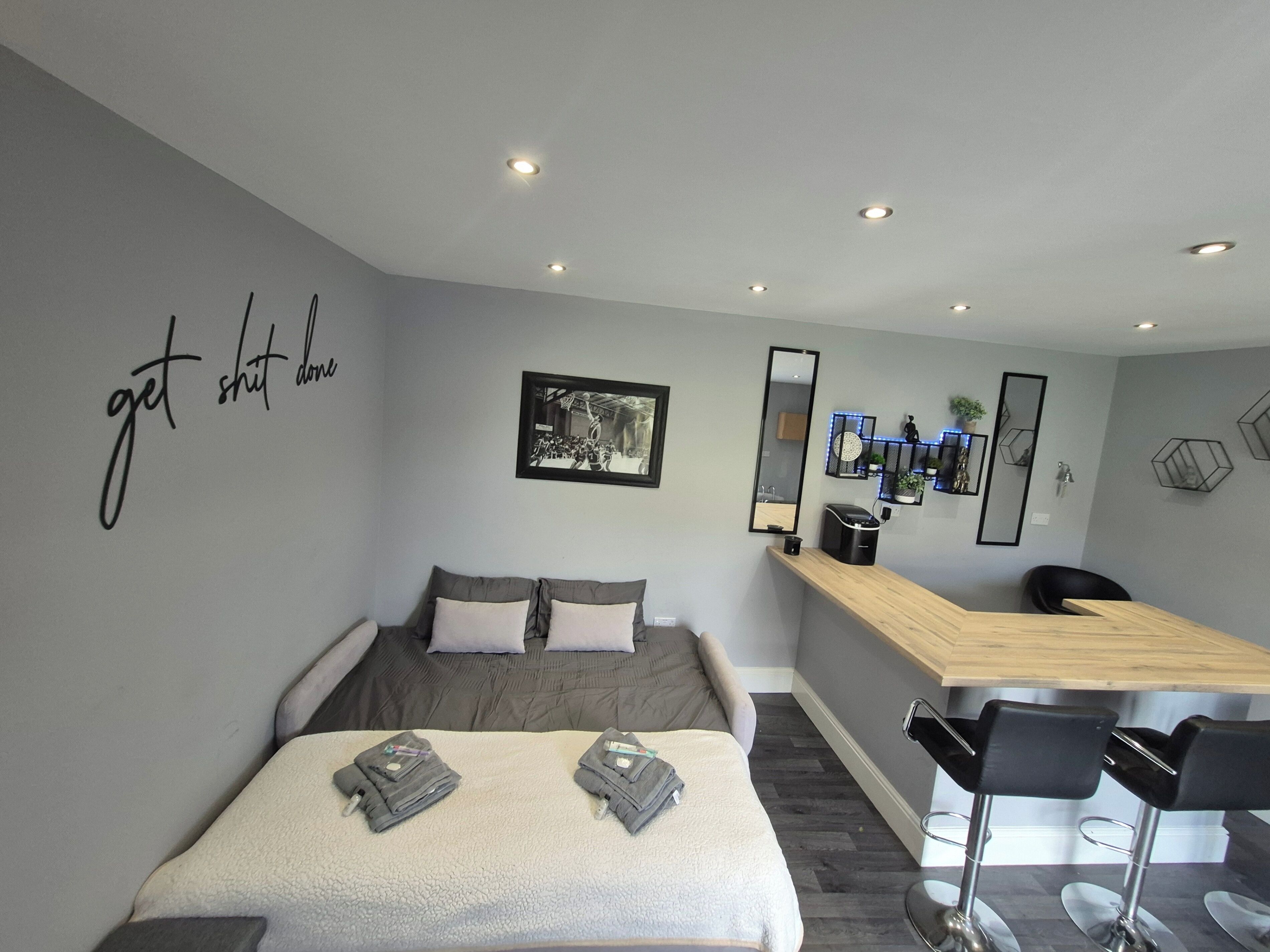 Une chambre d’hôtel moderne équipée d’un lit, d’un bureau et d’un coin bar.