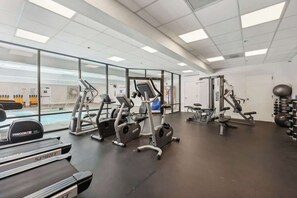 Ein Fitnessstudio mit Laufbändern, Crosstrainern und Kurzhanteln.