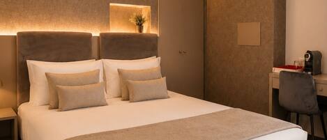 Une chambre d’hôtel moderne avec un grand lit, des tables de chevet, un bureau et une chaise.