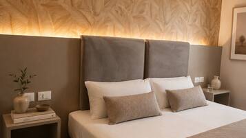 A modern bedroom with a large bed, a headboard with a leaf pattern, bedside tables, and a nightstand with a vase and books.