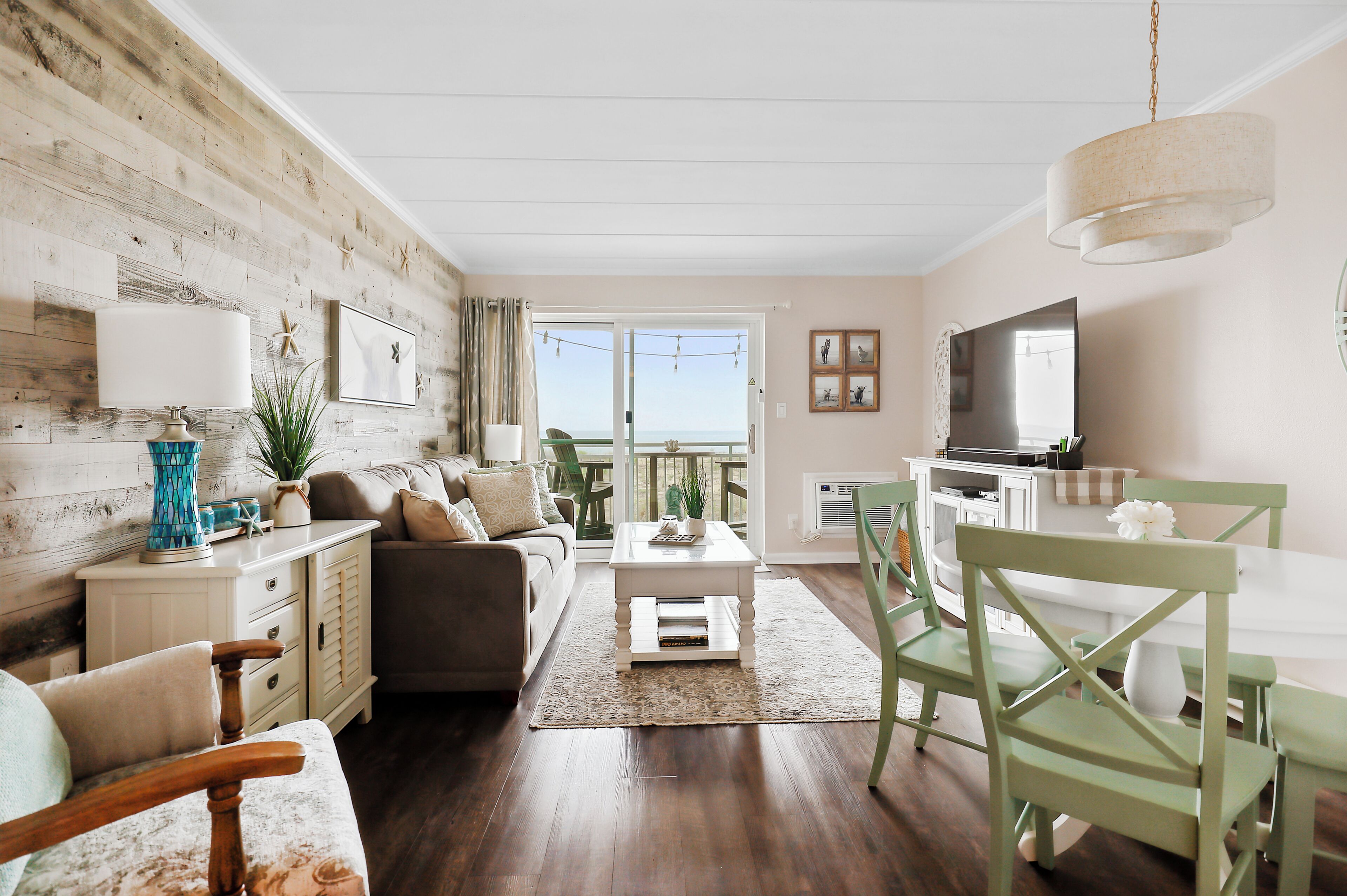 A living room with a sofa, coffee table, and dining area with chairs.
