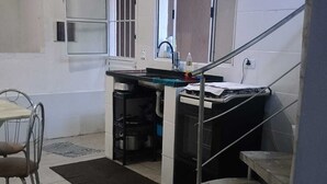 Une cuisine équipée d’une table à manger, de chaises, d’une cuisinière, d’un évier et d’un escalier.