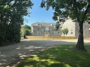 A stone building with a gravel driveway and a wooden fence. - The Little Vicarage (Highbridge)