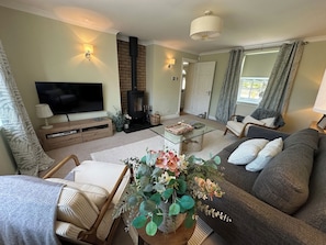 A living room with a sofa, TV, fireplace, and a coffee table with decorative items.