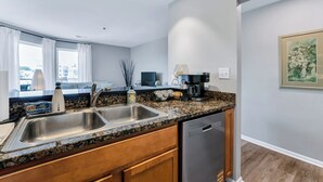 A modern kitchen with granite countertops, stainless steel appliances, and a dishwasher. - Virginia Beach Condo With Balcony & Pool (Virginia Beach)