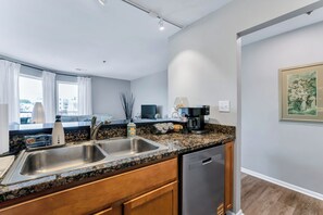 A modern kitchen with granite countertops, stainless steel appliances, and a dishwasher. - Virginia Beach Condo With Balcony & Pool (Virginia Beach)