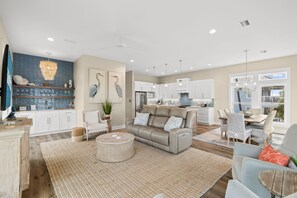 A spacious living area with a sofa, coffee table, and dining set.
