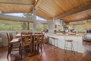 A spacious kitchen with a large island, wooden ceiling, and a view of the outdoors. - Classic Snowmass Village Ski Chalet,  Ski-in! (Snowmass Village)