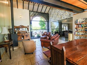 A spacious living area with a fireplace, leather sofa, wooden coffee table, and a bookshelf. - Bib Knowl Farm (Rochdale)