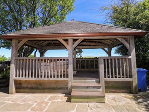 A wooden gazebo with a tiled roof, stone steps, and a wooden railing. - Bib Knowl Farm (Rochdale)
