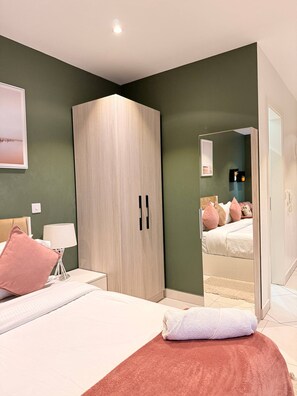 Ein modernes Schlafzimmer mit Bett, Kleiderschrank, Nachttisch und Spiegel.