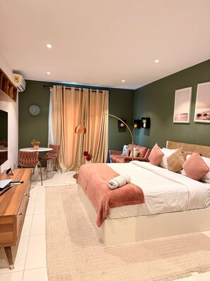 Ein Schlafzimmer mit einem Bett, einem Nachttisch, einem Stuhl und einem Schreibtisch mit Lampe.