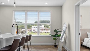 Una cocina moderna con barra, ventanas amplias y vistas al exterior.
