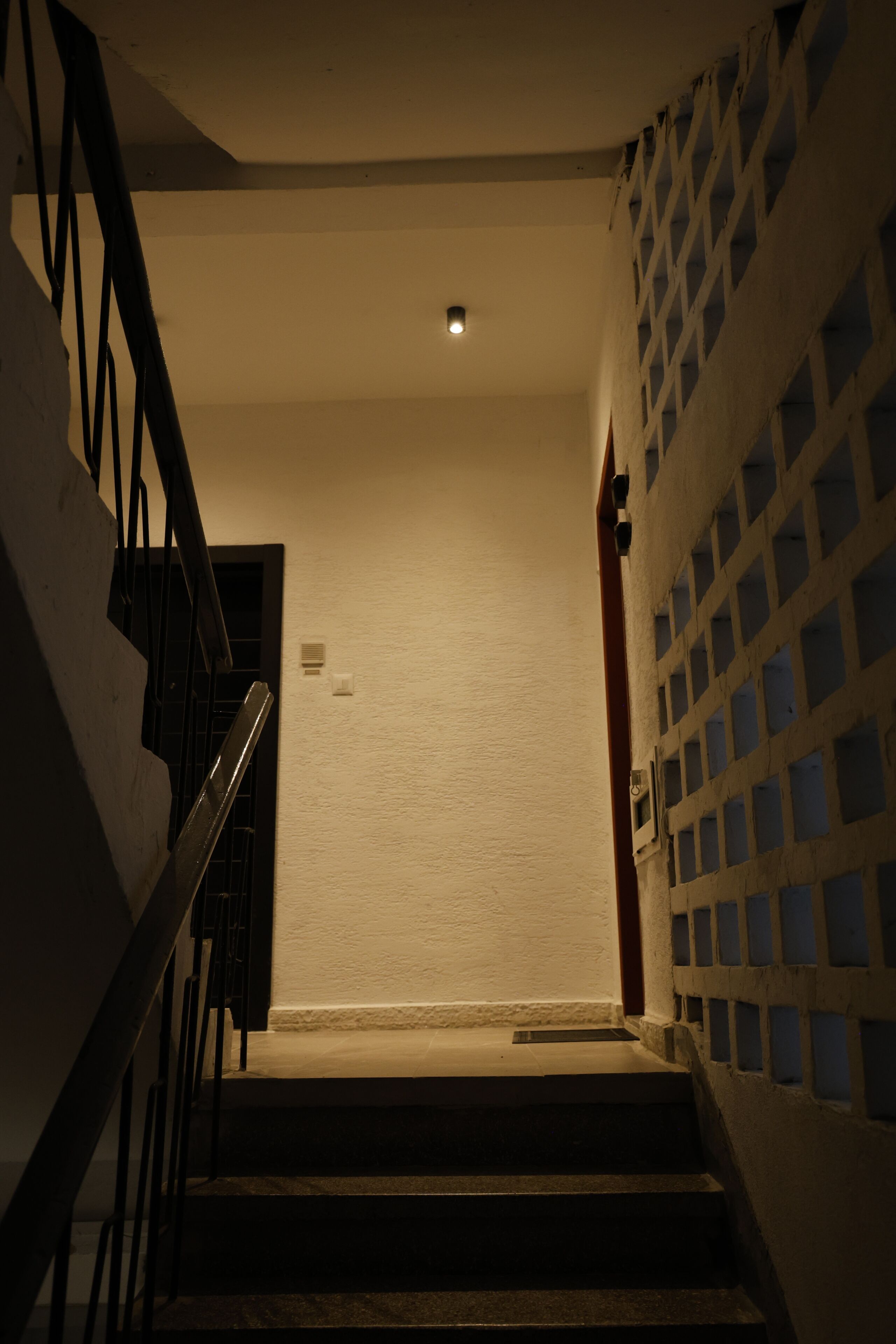 A staircase with a handrail leading to a landing.