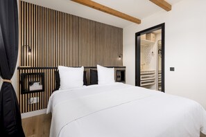 Ein Hotelzimmer mit einem großen Bett, einer Wandpaneele aus Holz und einem Schrank mit Spiegel.