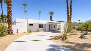 A modern house with a white exterior, a covered patio, and a paved driveway. - Modern Villa|Palm Desert|Great location|Pool|Spa (Palm Desert)
