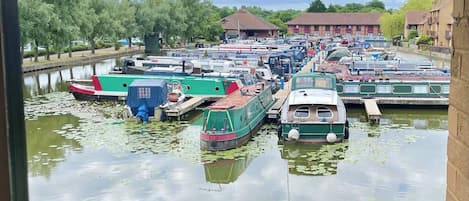 A canal with boats docked, surrounded by trees and buildings.