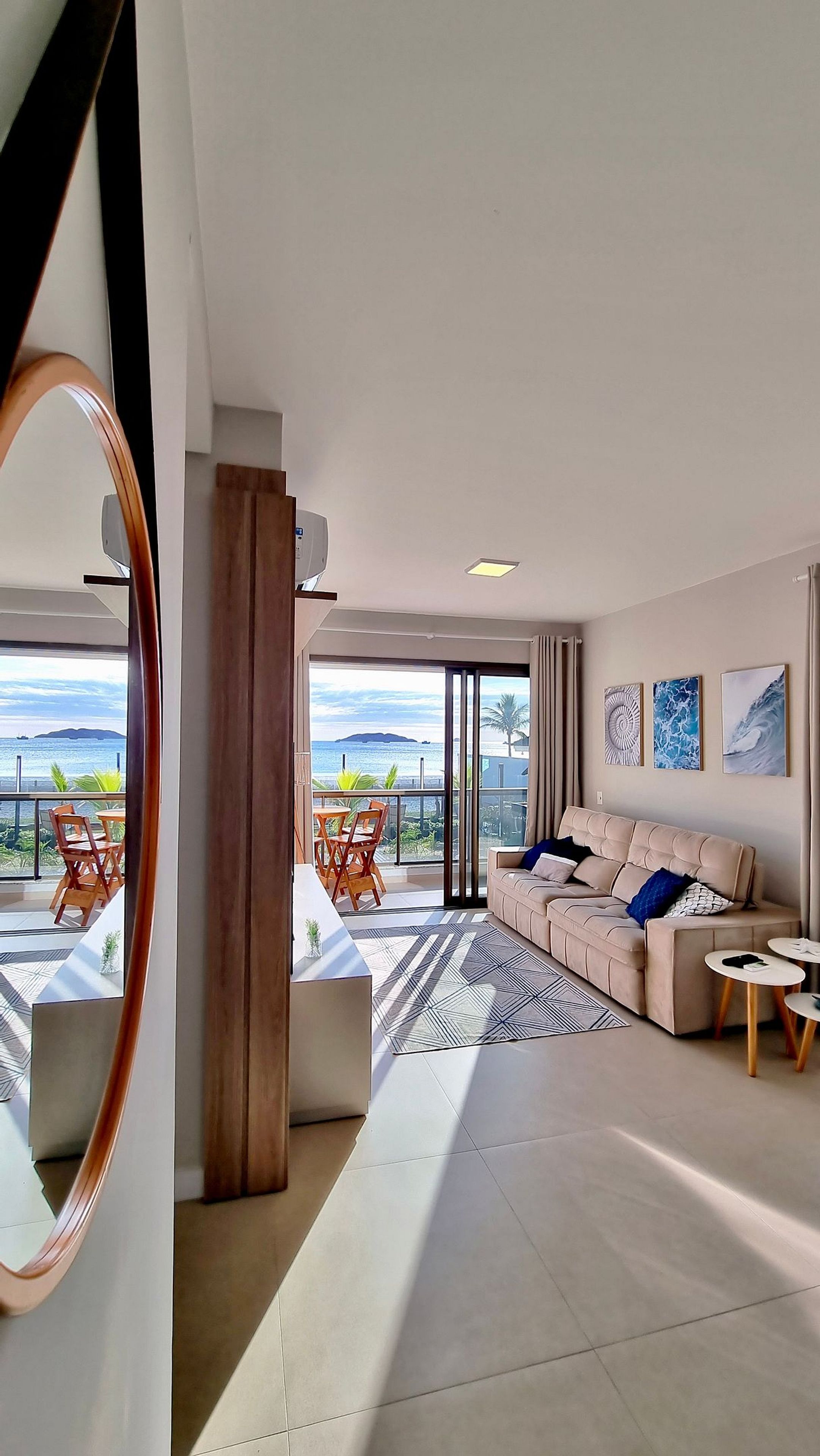 Een moderne woonkamer met een bank, salontafel en uitzicht op zee.