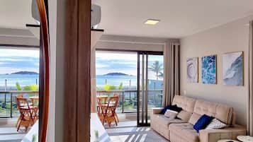 Een moderne woonkamer met een bank, salontafel en uitzicht op zee.