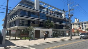 A multi-story building with a modern architectural design, featuring balconies and large windows.