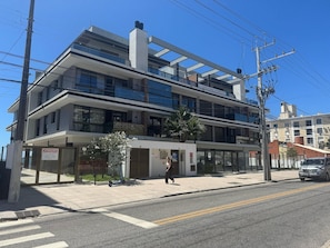 A multi-story building with a modern architectural design, featuring balconies and large windows.