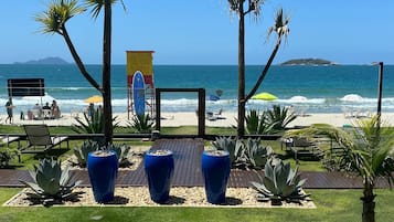 Aan het strand, wit zand, ligstoelen aan het strand, parasols