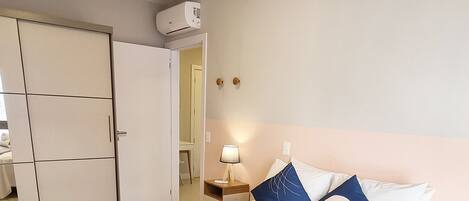 A neatly arranged bedroom with a bed, bedside tables, a lamp, and a wardrobe.