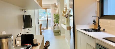 Una cocina moderna con estufa integrada, refrigerador y comedor con mesa y sillas.