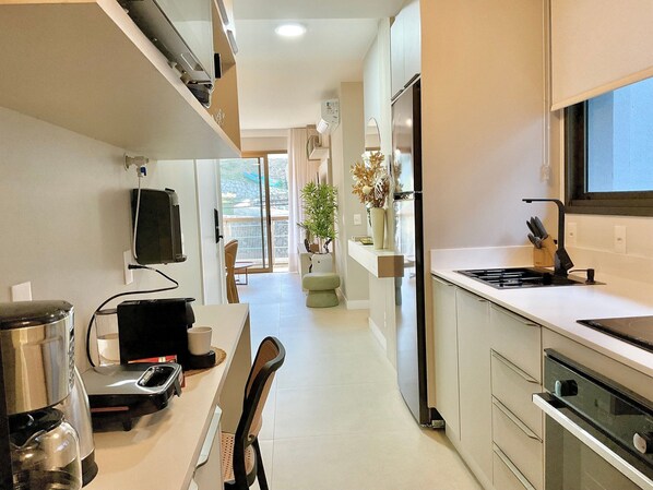 Une cuisine moderne équipée d’une cuisinière intégrée, d’un réfrigérateur et d’un coin repas avec une table et des chaises.