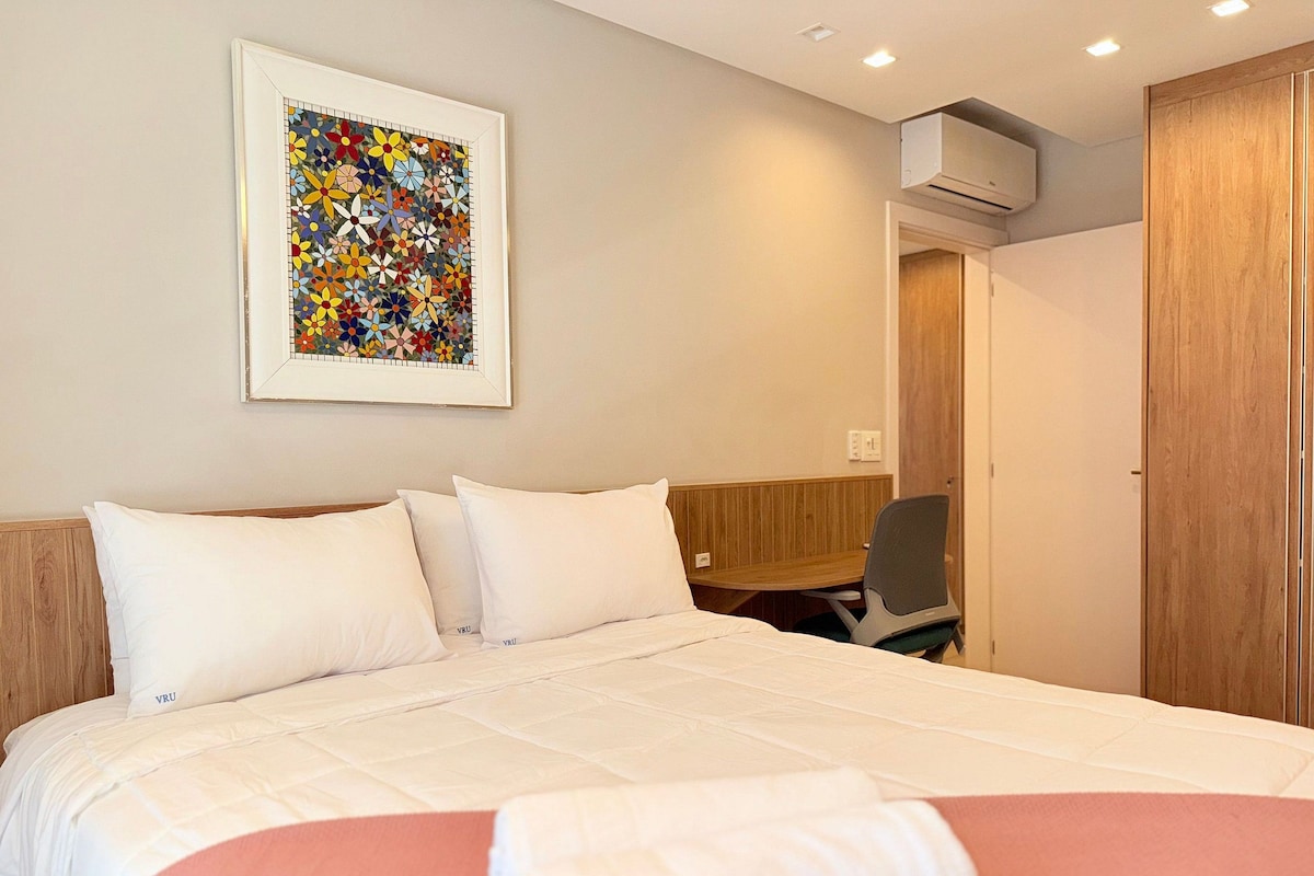 Une chambre d’hôtel équipée d’un lit, d’un bureau et d’un appareil de climatisation.