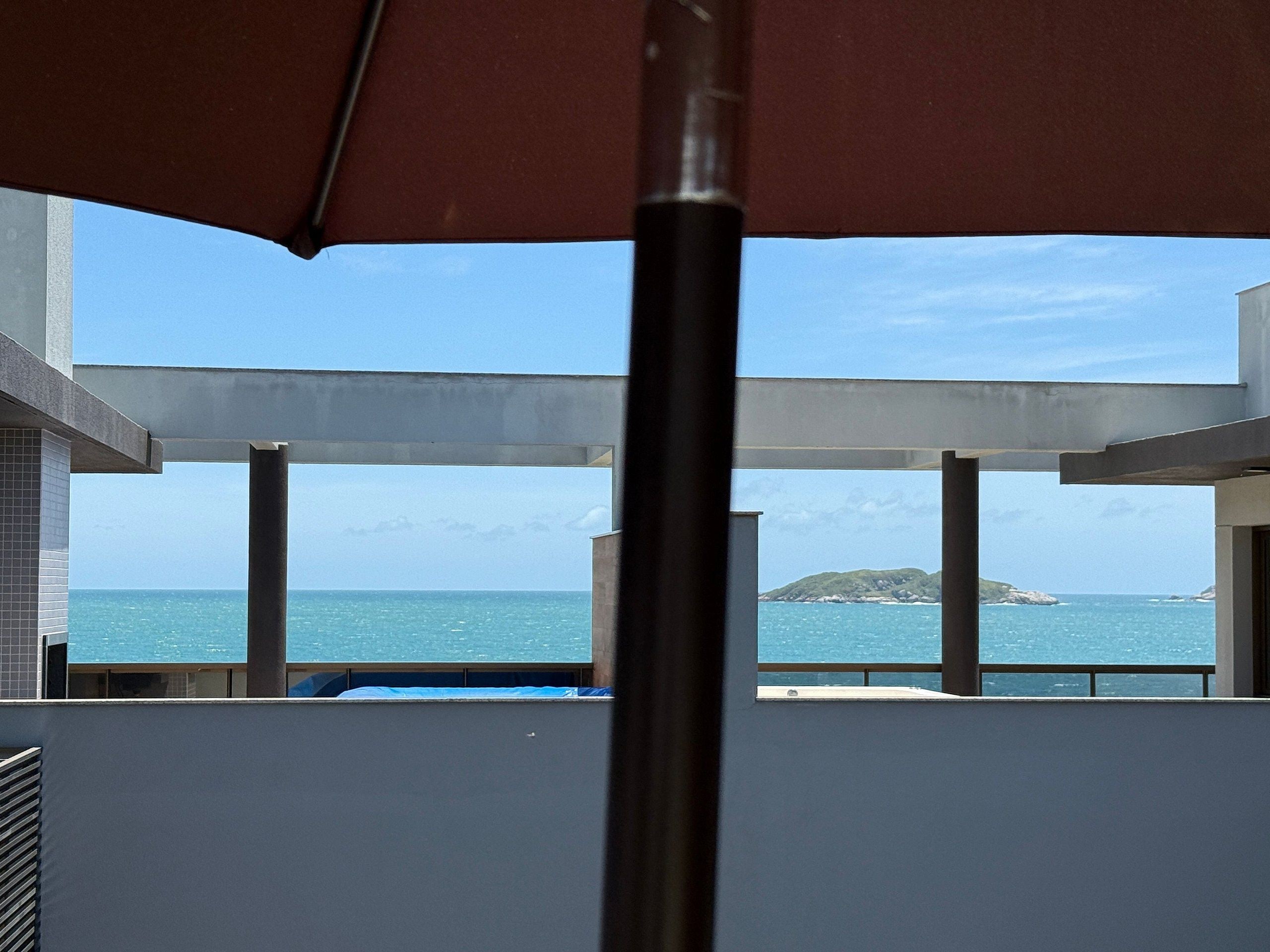 Un balcon avec vue sur la mer et une petite île.