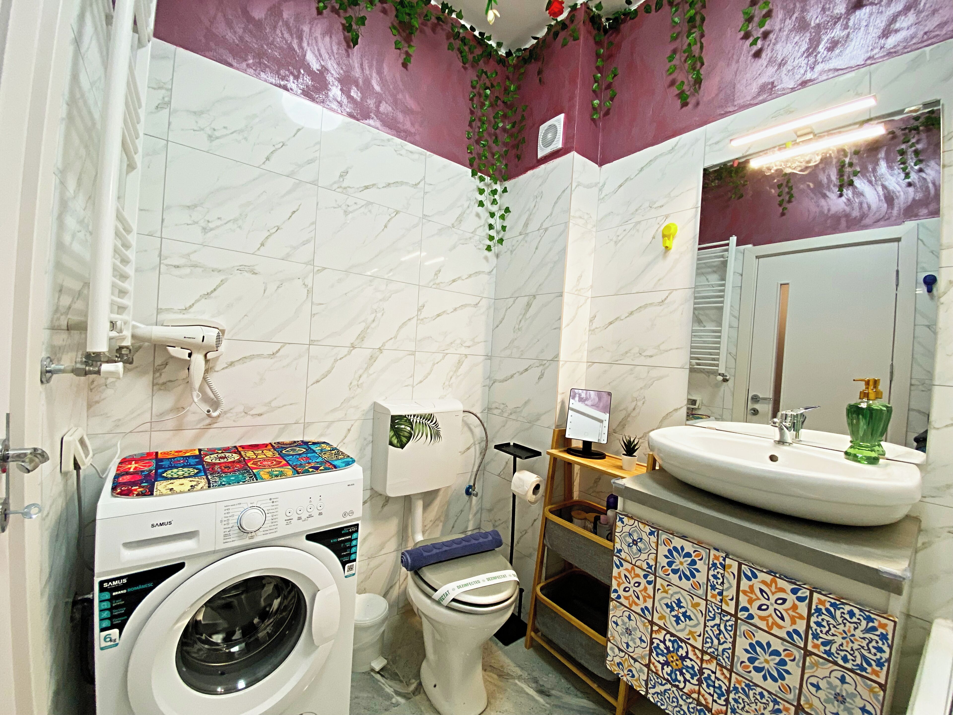 Baño con lavadora, inodoro y lavabo.