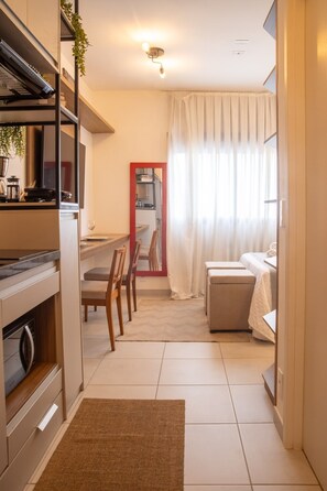 Ein kompakter Wohnraum mit Küchenzeile, Essbereich und Schlafzimmer.