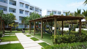 A courtyard with a wooden pergola, hammock, and a checkered pathway. - Almarena (Mazatlán)