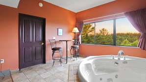 A bathroom with a bathtub, a door, a window with a view, and a chair. - River View Condo - Top Floor - Resort Pools - Pet Friendly! (Wisconsin Dells)