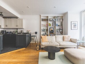 Ein moderner Wohnbereich mit Küche, Essbereich und einer gemütlichen Sitzecke mit Sofa und Couchtisch.