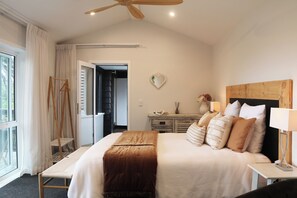 Ein Schlafzimmer mit Bett, Nachttisch und Deckenventilator.