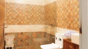 Un bagno con doccia, WC e lavandino.