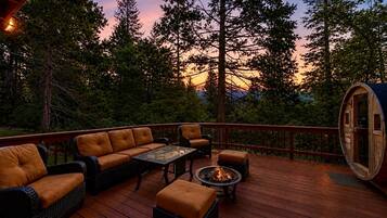 Une terrasse dotée de mobilier d’extérieur, d’un foyer et d’un tonneau en bois.