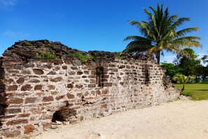 An old stone building with a palm tree in the background. - Fort Morgan Cay, Roatan: 40-Acre Private Island from 10-20 Guests - 8 Bedrooms (Roatan)