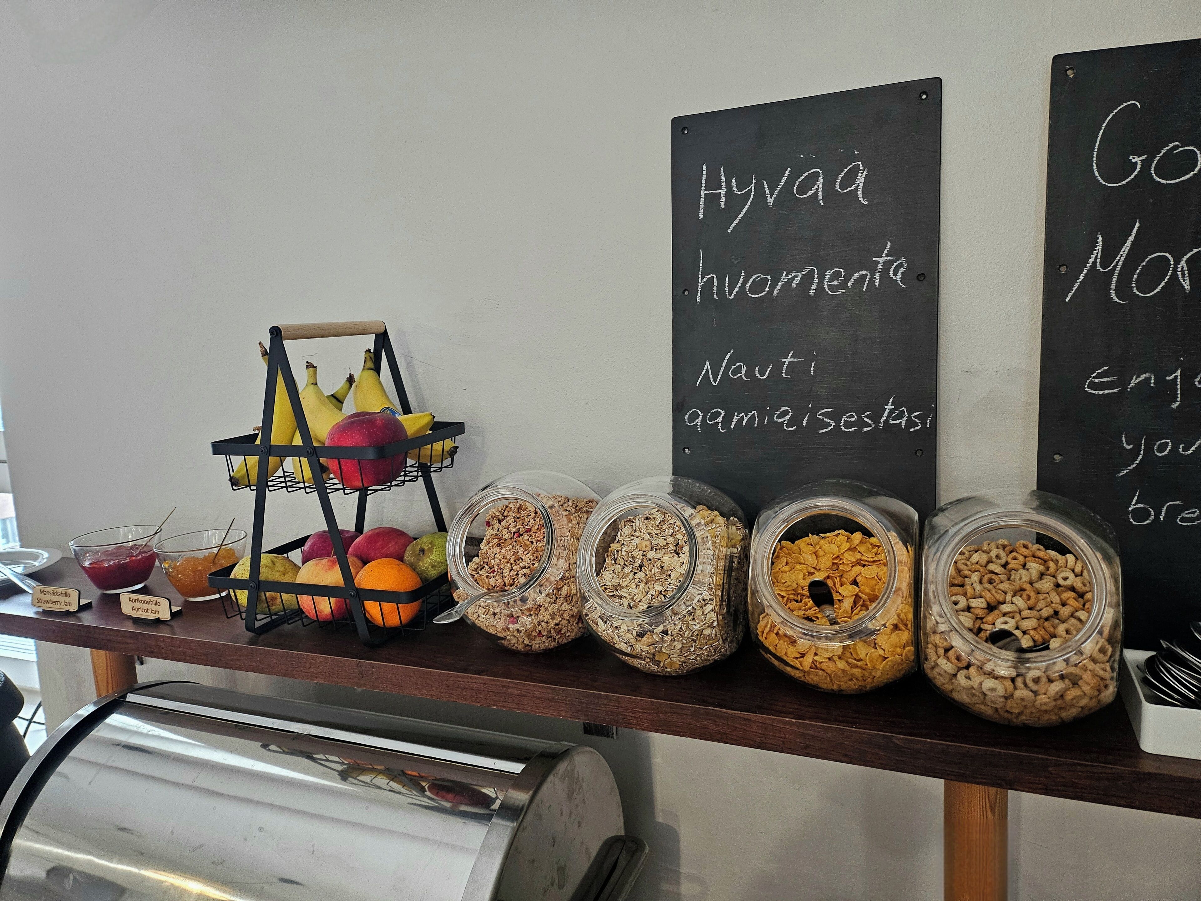 Una barra de desayuno con fruta, cereales y mermelada.
