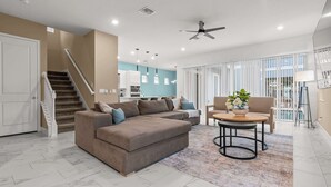 Ein modernes Wohnzimmer mit einer Couch, einem Couchtisch und einer Treppe.