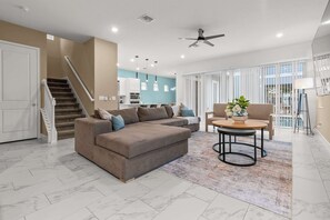 Ein modernes Wohnzimmer mit einer Couch, einem Couchtisch und einer Treppe.