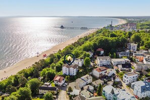 An aerial view of a coastal town with a beach, a pier, and residential buildings. - Vacation apartment near the beach for 4 people with terrace (Heringsdorf)