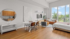 A modern hotel room with a dining area, a bed, a TV, and a balcony with a view. - Bayfront Vizcayne Condo w/ Pool & Free Parking (Miami)