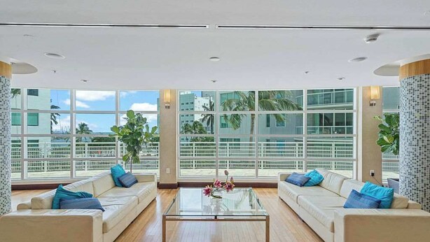 A spacious living area with two sofas, a coffee table, and large windows offering a view of the cityscape. - Bayfront Vizcayne Condo w/ Pool & Free Parking (Miami)