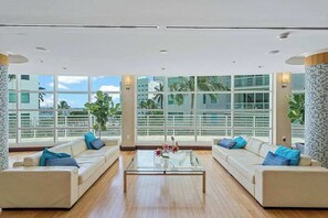 A spacious living area with two sofas, a coffee table, and large windows offering a view of the cityscape. - Bayfront Vizcayne Condo w/ Pool & Free Parking (Miami)