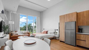 A modern room with a bed, a dining table, and a kitchen area. - Bayfront Vizcayne Condo w/ Pool & Free Parking (Miami)