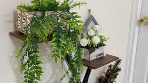 Estante de pared con plantas en macetas y objetos decorativos.